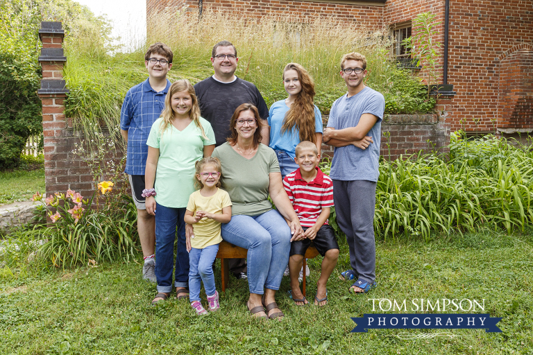 family portrait by red brick building grass on top