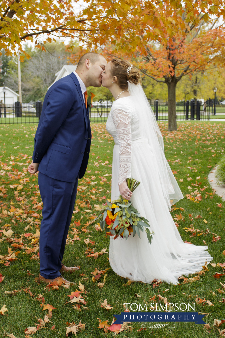 bride groom kissing fall trees