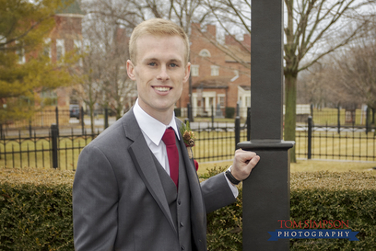 groom in gray red overcast sky