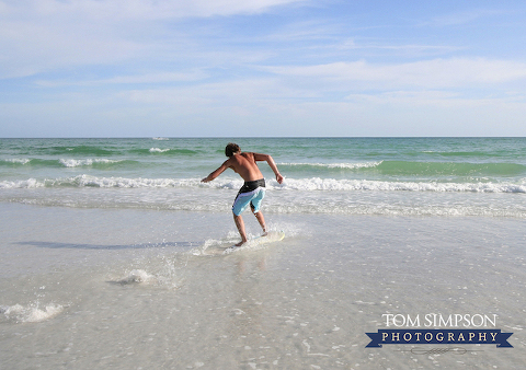 teen on skimboard at siesta key beach fl